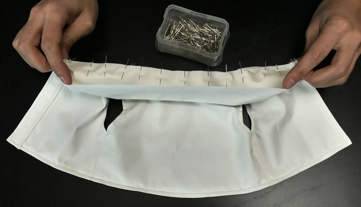 Your collar should be turned "right" side out, and pressed before you pin it to the neckline. Pins should be placed along the "wrong" side which is now the inside of your collar, and also the underside.