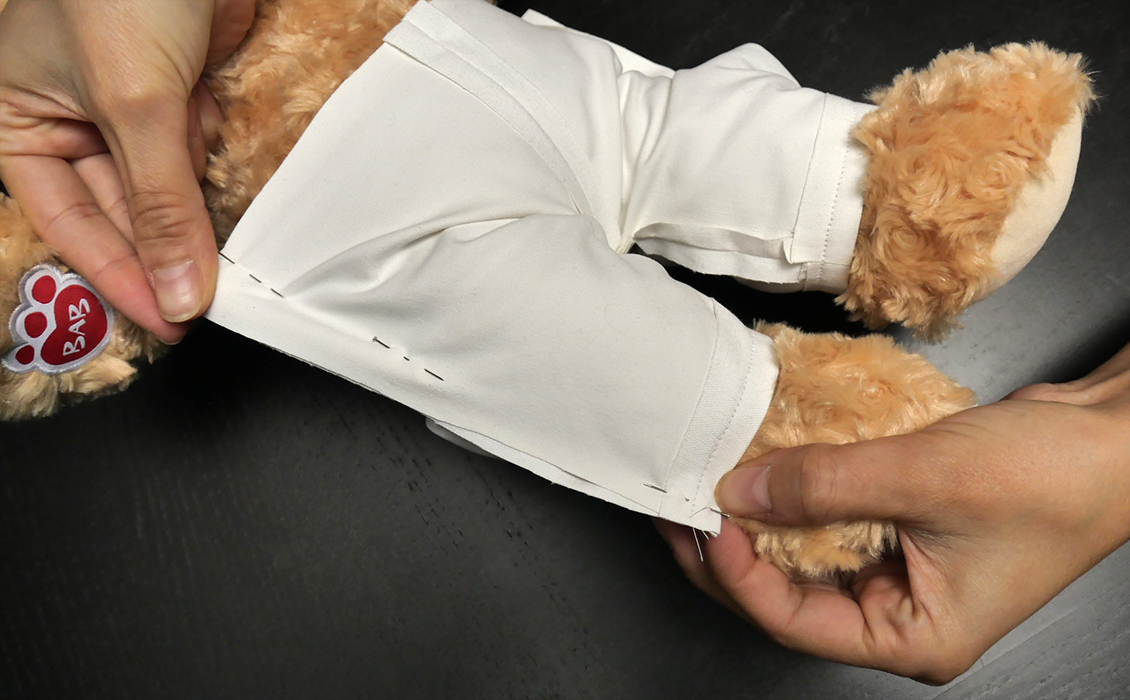First, pin to fit. Take up the slack on either side, paying close attention to the desired fit around the waist and the pant cuffs.