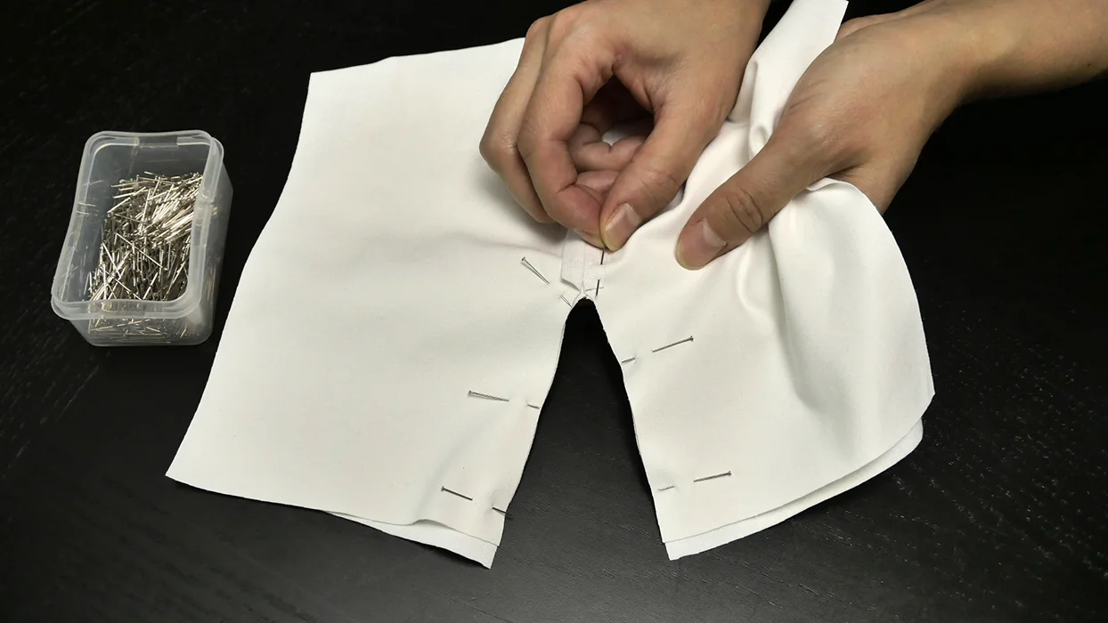 Pin to secure, then run a continuous seam around this curve, from cuff to cuff.