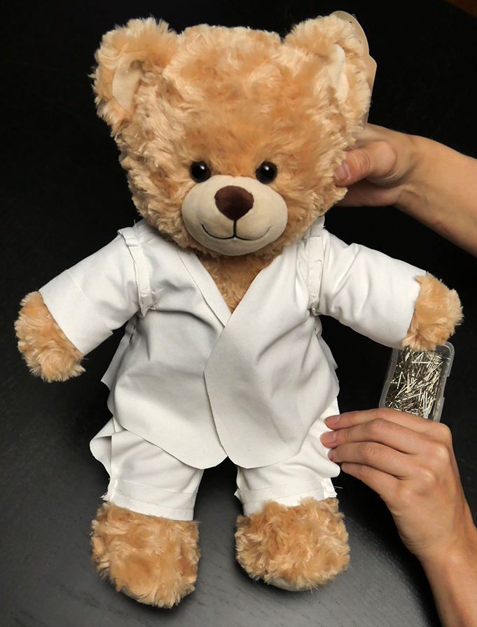 It is much easier to adjust the length of your sleeves with the jacket on your bear, like so.