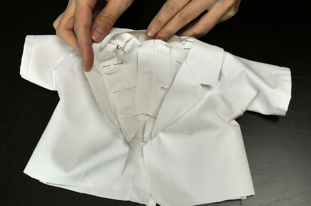 Pin the lapel in place from the inside. This seam should follow the contour of the neckline.