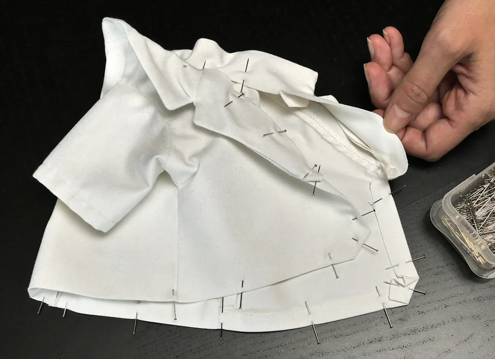 Stitch the lapel closed AND stitch the hem in place at the same time.