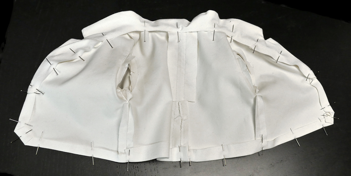 See how this row of pins makes what looks like a big circle all the way around? Your last stitches should follow this entire contour continuously, starting at the vent and stopping at the vent. Remember: your vent has two sides!