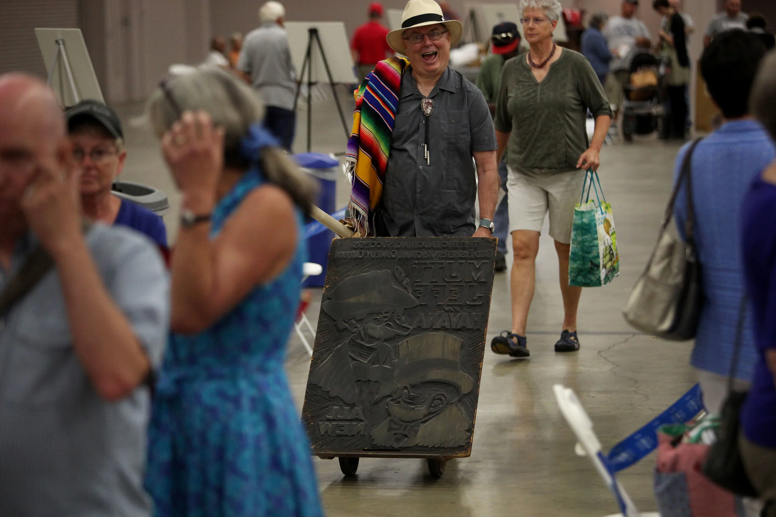 Bill, of Gallup, rolls his antique movie poster wood cut down the line at Antiques Roadshow at the Albuquerque Convention Center, July 19, 2014, in Albuquerque NM. The poster was for the early 1900s movie "Mutt and Jeff in Havana." (Morgan Petroski/Journal)