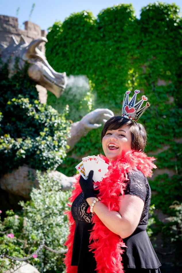 woman dressed as queen of hearts with cards and dragon