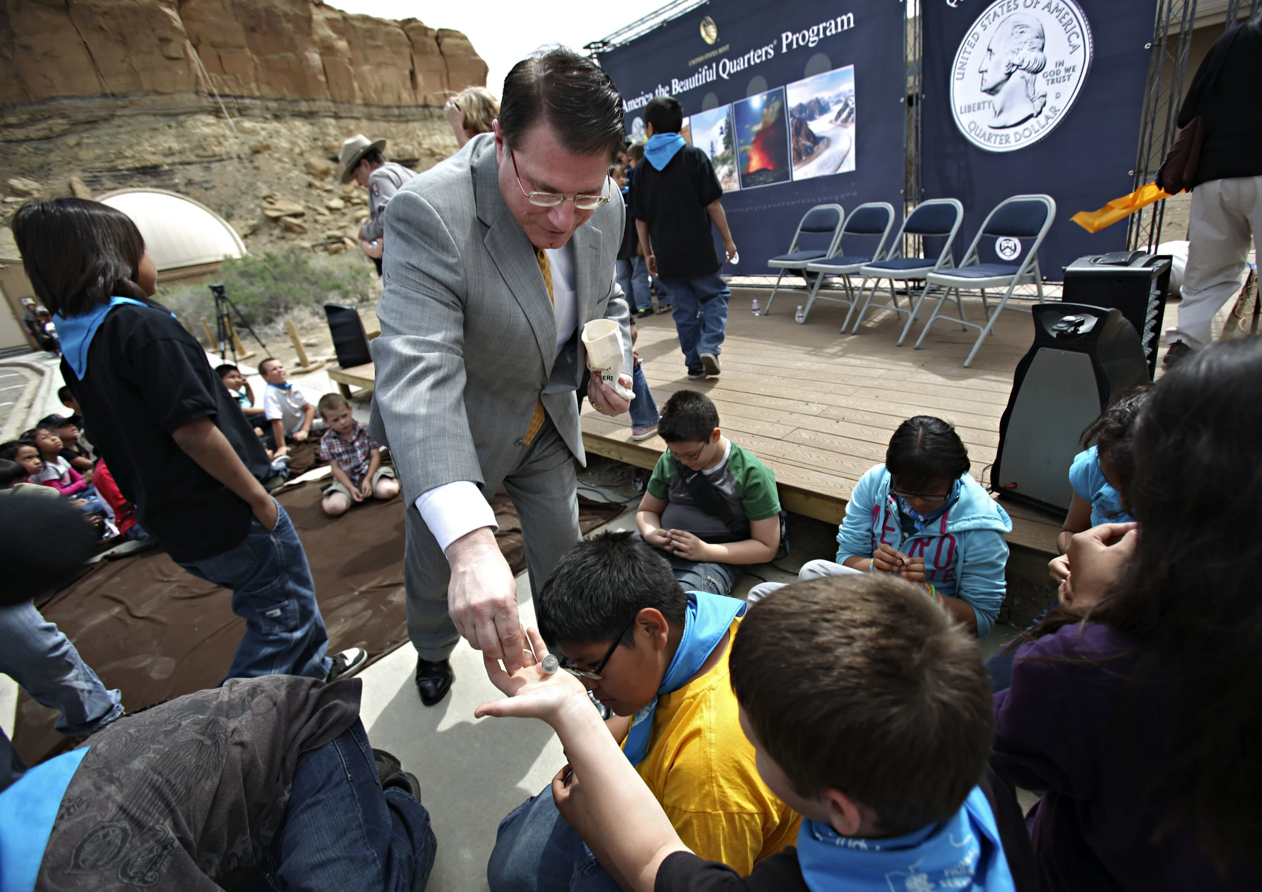 Deputy Director of the United State Mint Richard Peterson hands out Chaco Canyon quarters to 5th graders from Apache Elementary during the quarter launch at Chaco Canyon, Thursday, April 26, 2012. (Morgan Petroski/Albuquerque Journal)