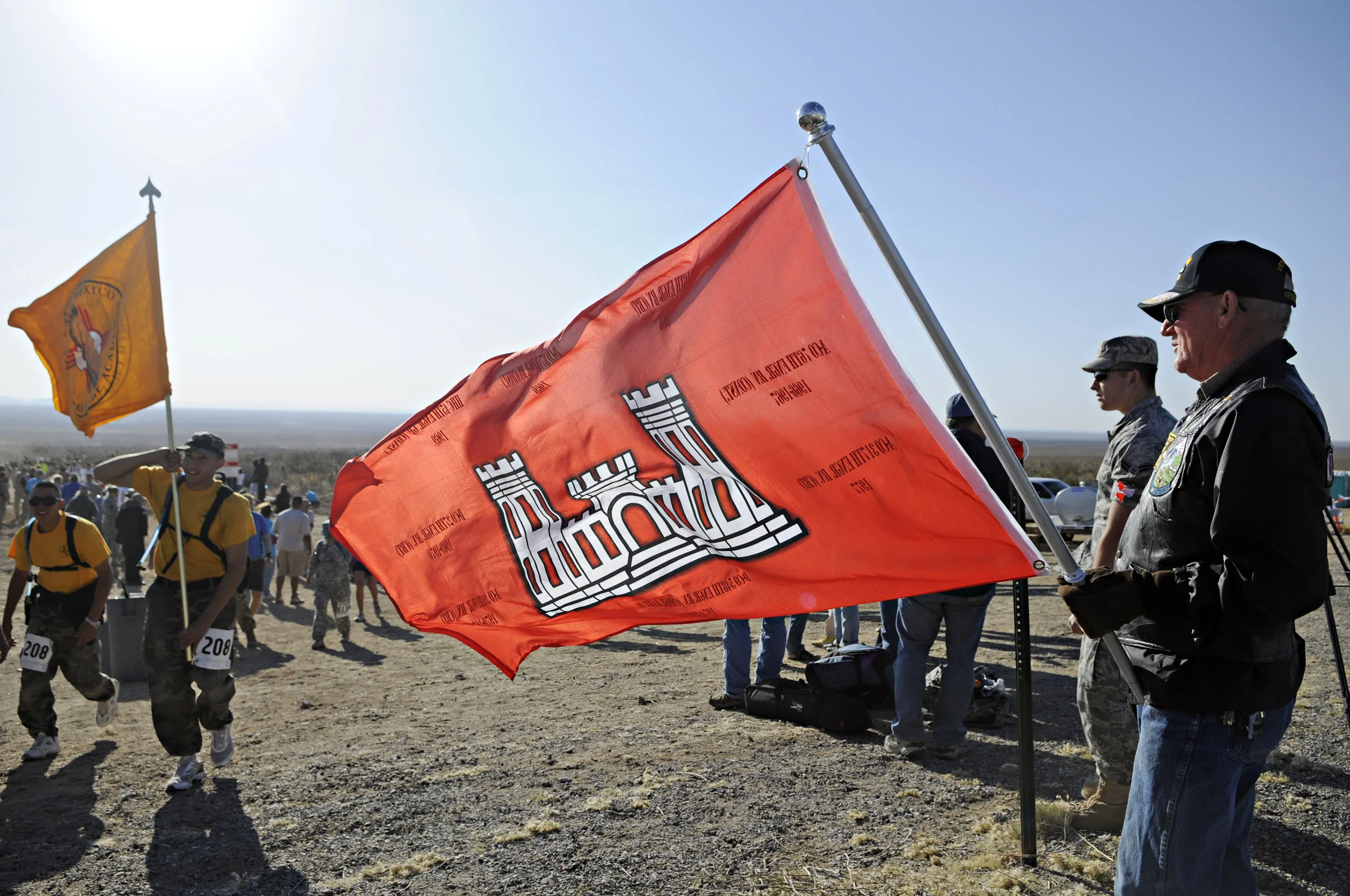 Vietnam veteran Bruce Fonnest, at right, holds up the Engineer flag as walkers and runners pass by at water station 3 during the 22nd Annual Bataan Memorial Death March at White Sands Missile Range, Sunday, March 27, 2011. (Morgan Petroski/Albuquerque Journal)