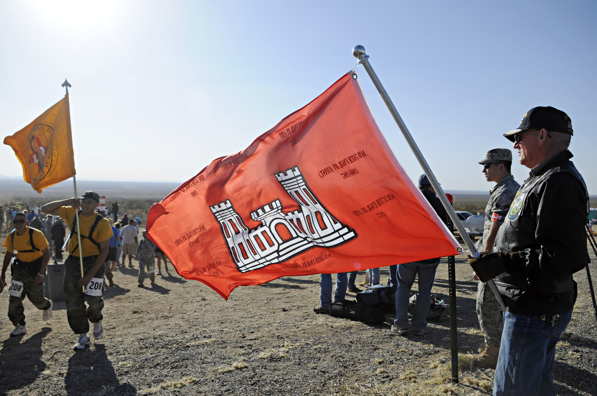  Vietnam veteran Bruce Fonnest, at right, holds up the Engineer flag as walkers and runners pass by at water station 3 during the 22nd Annual Bataan Memorial Death March at White Sands Missile Range, Sunday, March 27, 2011. (Morgan Petroski/Albuquerq