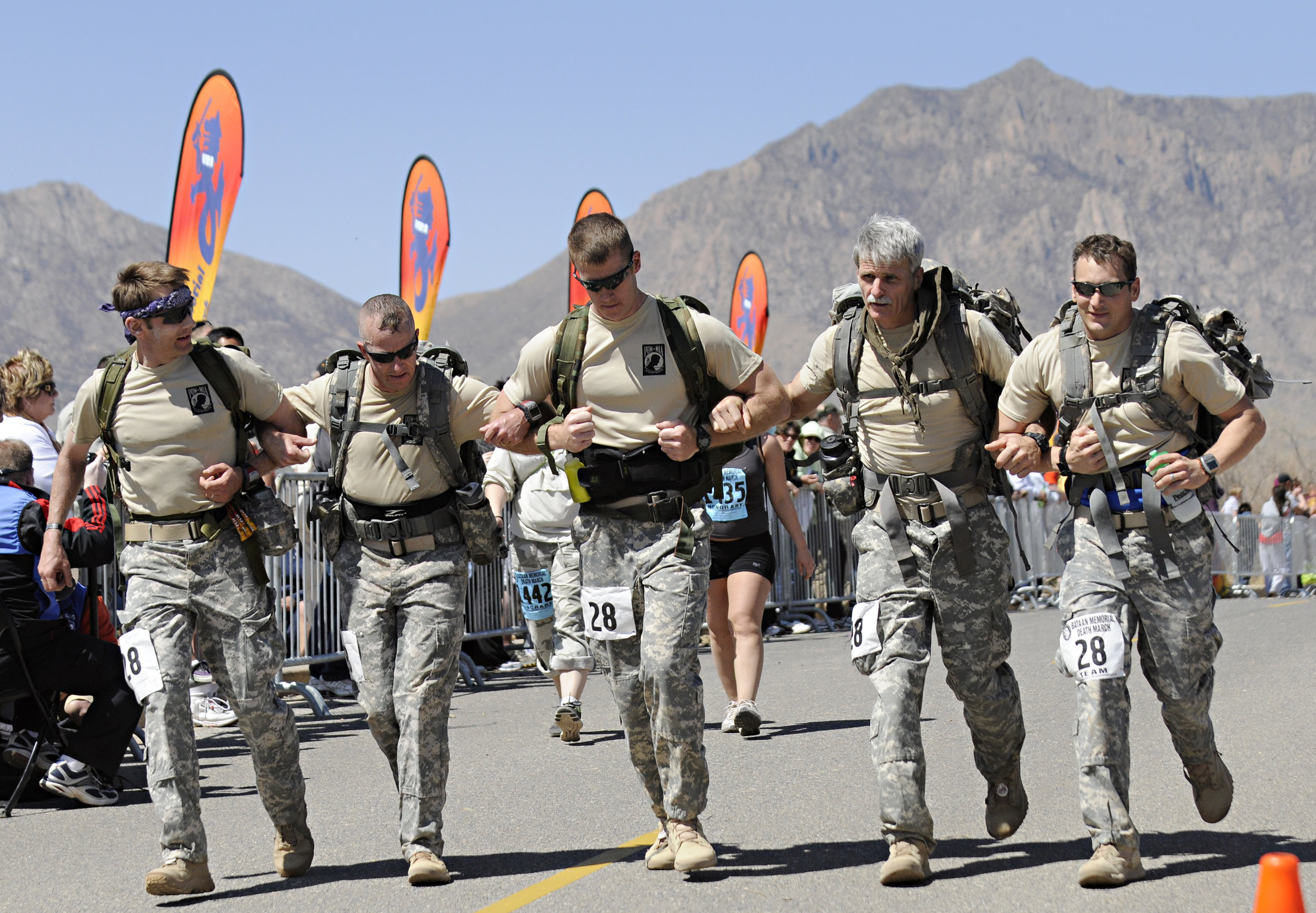  A team prepares to cross the finish line of their 26.2-mile run arm in arm during the 22nd Annual Bataan Memorial Death March at White Sands Missile Range, Sunday, March 27, 2011. (Morgan Petroski/Albuquerque Journal) 
