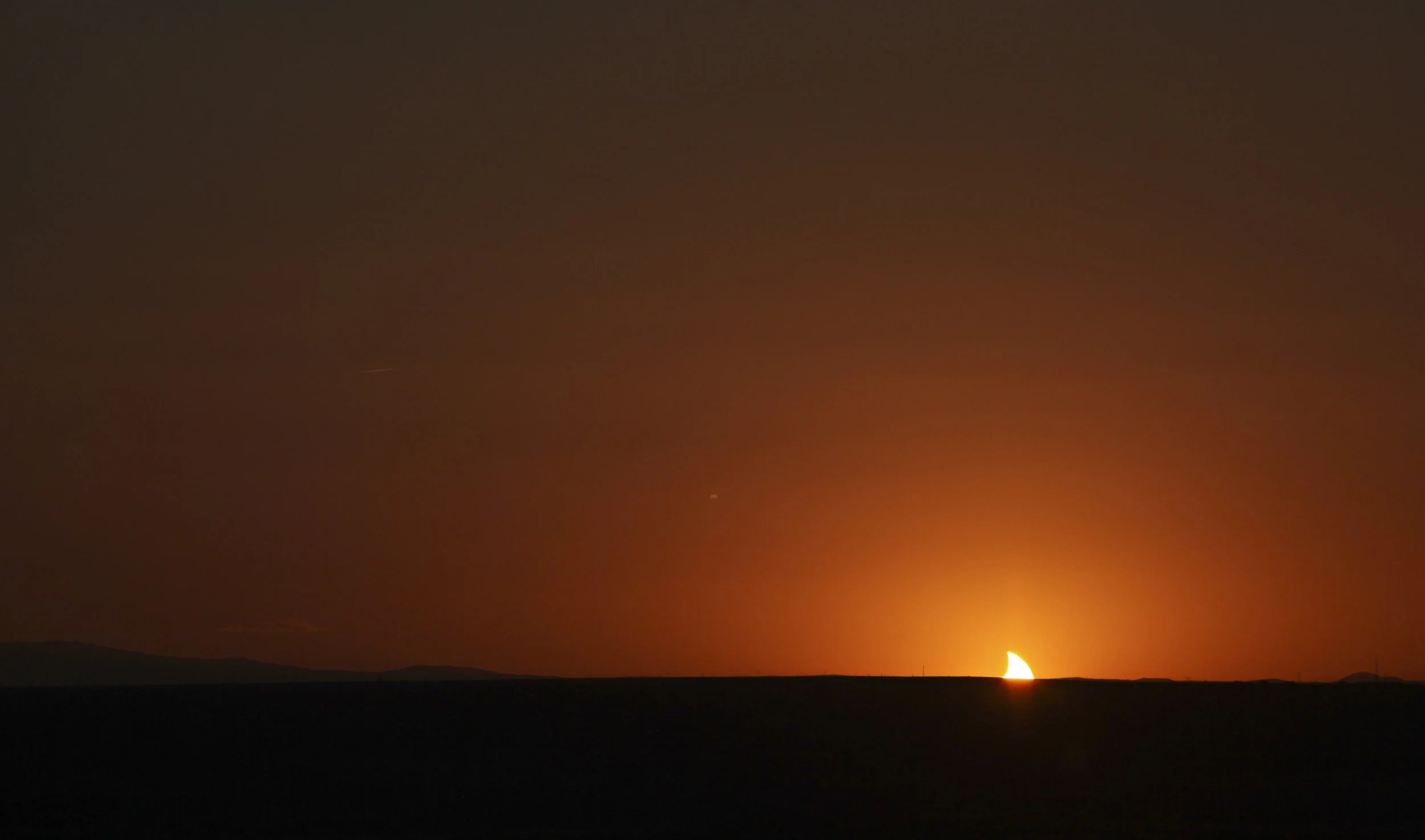 The setting sun appears like a shark fin as it dips below the horizon while completing the annular solar eclipse as viewed near the Hard Rock Casino Presents the Pavilion, Sunday, May 20, 2012, in Albuquerque, NM. (Morgan Petroski/Albuquerque Journal)