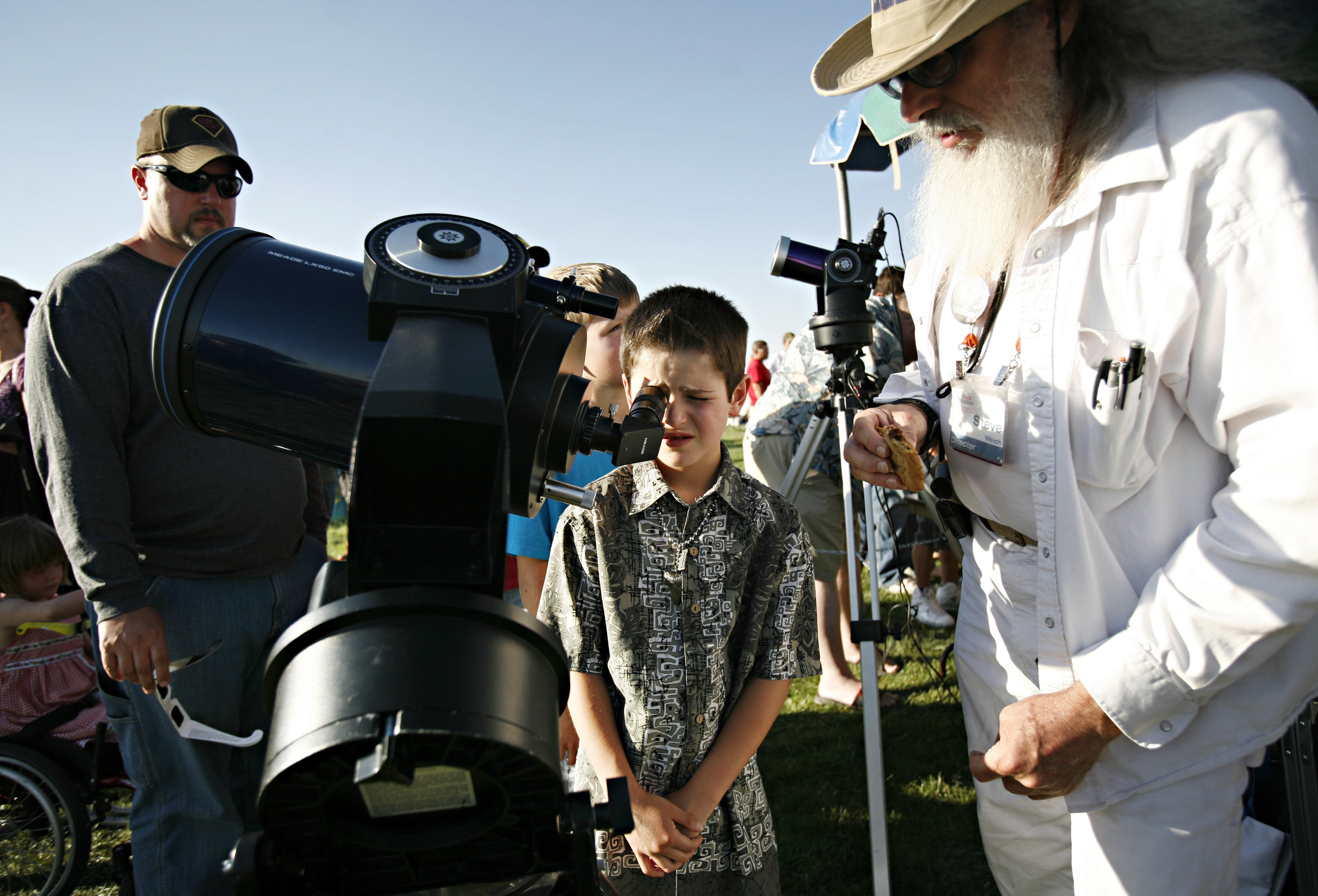  Xavier Martin, 8, looks at the sun through a telescope manned by TAAS member Steve Welch, at right, during the annular solar eclipse viewing party near the Hard Rock Casino Presents the Pavilion, Sunday, May 20, 2012, in Albuquerque, NM. (Morgan Pet