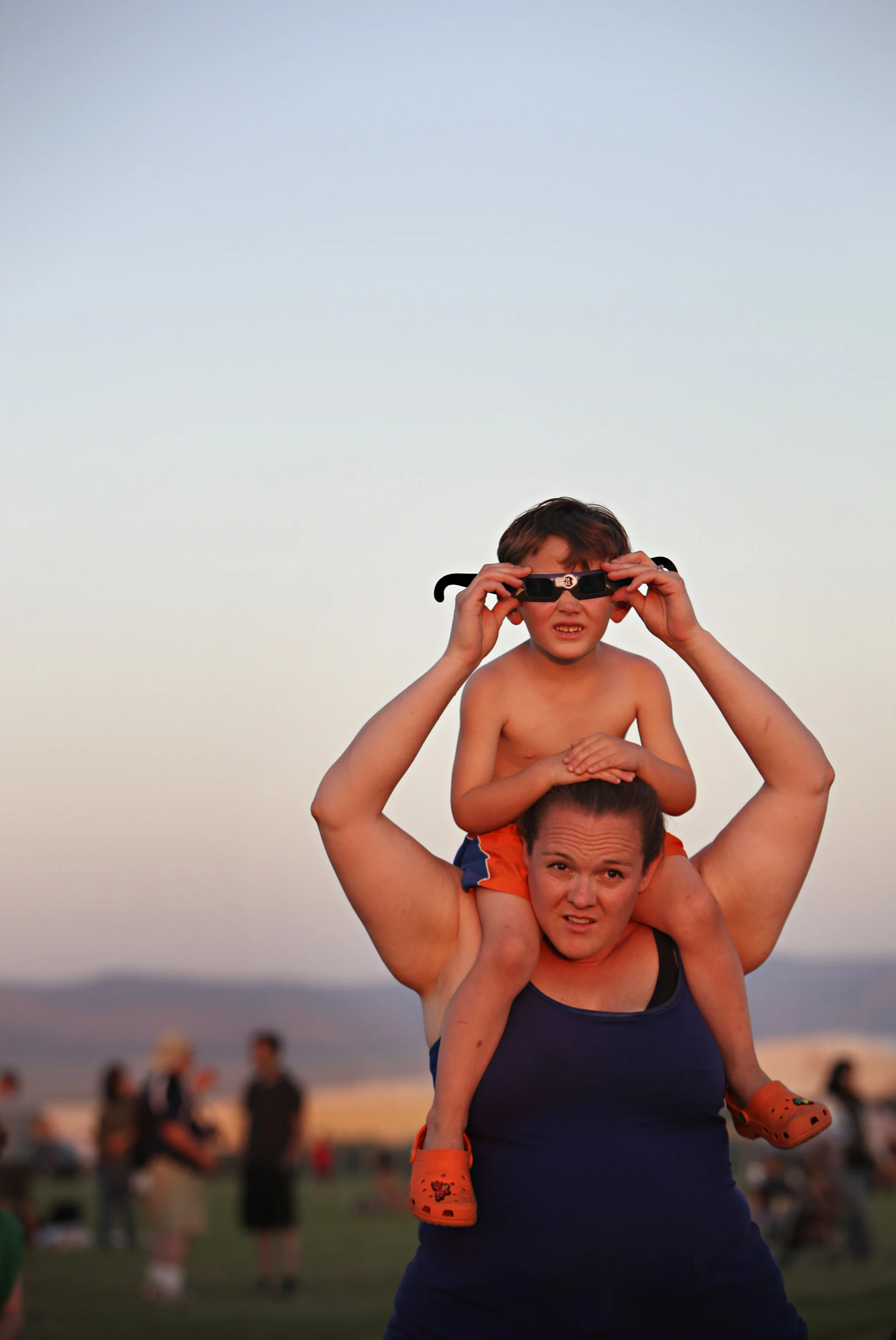 Jaxon Wright, 4, looks at the annular solar eclipse through special glasses while sitting on his mother, Tiffany Wright's, shoulders during the viewing party near the Hard Rock Casino Presents the Pavilion, Sunday, May 20, 2012, in Albuquerque, NM. (Morgan Petroski/Albuquerque Journal)