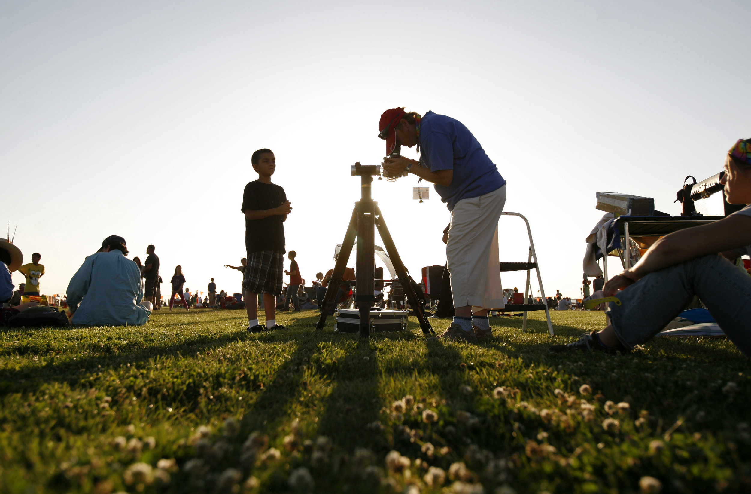  At right, Amy Estelle, with The Albuquerque Astronomical Society, adjusts the telescope, as Joseph Salazar, 9, waits to take a look at left, during the annular solar eclipse viewing party near the Hard Rock Casino Presents the Pavilion, Sunday, May 