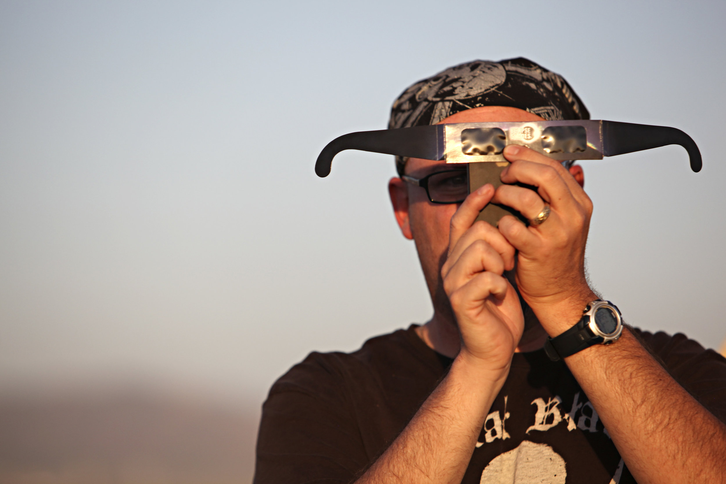  John Converse, of Albuquerque, takes a cell phone photo of the annular solar eclipse through the lens of a pair of solar glasses during the eclipse viewing party near the Hard Rock Casino Presents the Pavilion, Sunday, May 20, 2012, in Albuquerque, 