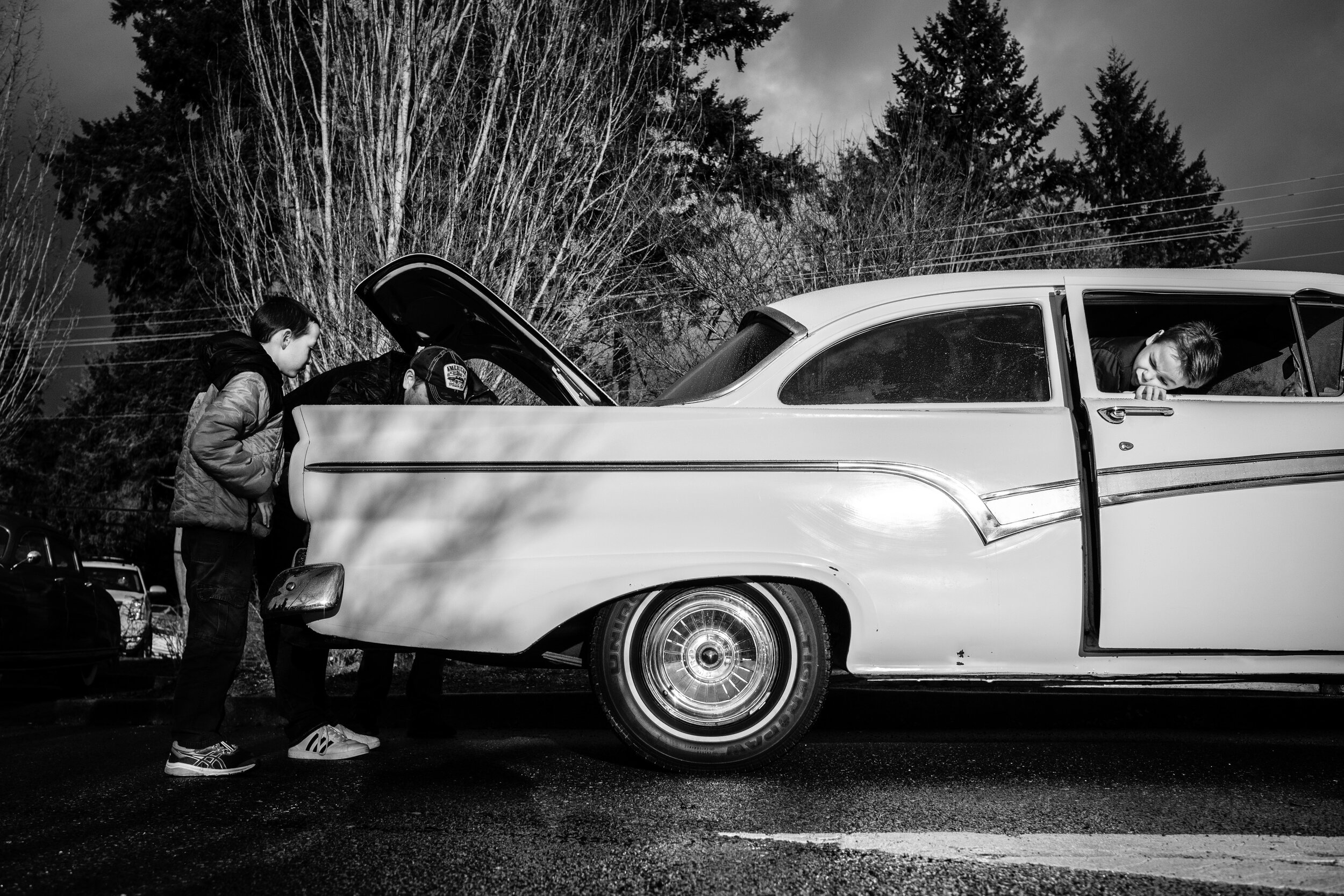 One boy checks out the truck, with the another peeks out the window,