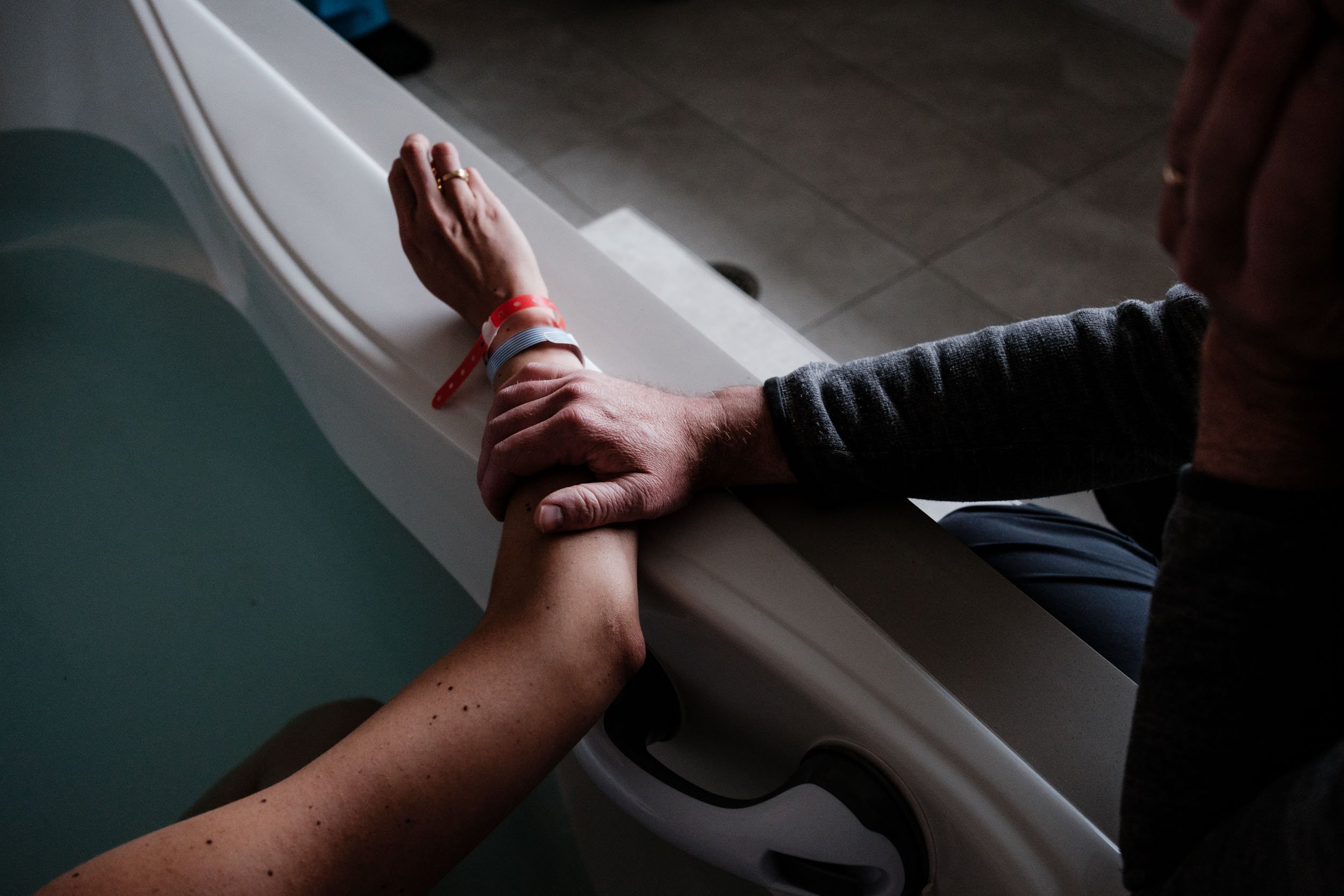 A husband gently touches his wife's arm during labor.