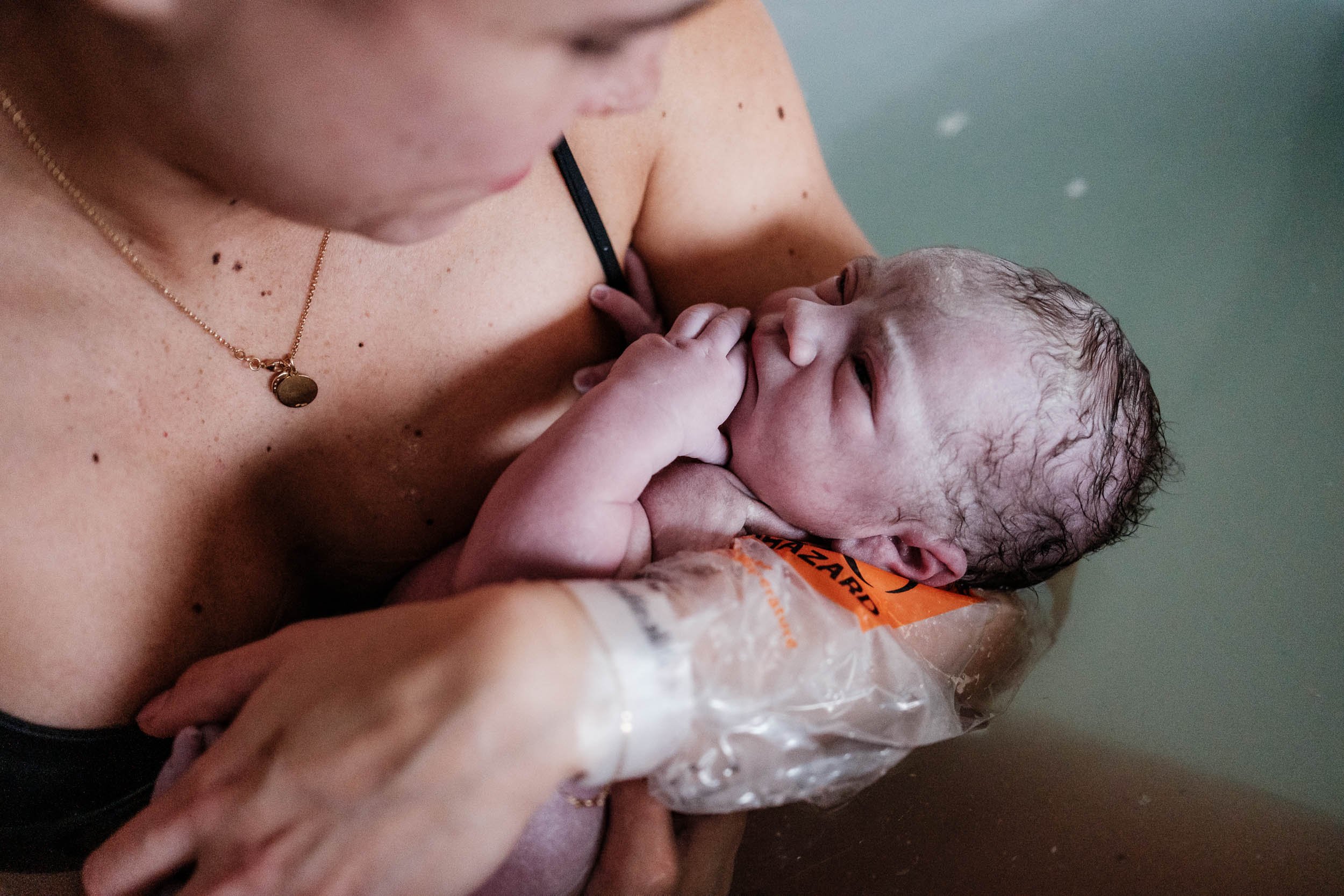 A freshly born baby looks up at his mother while still in the birth tub at Virginia Mason in Seattle.
