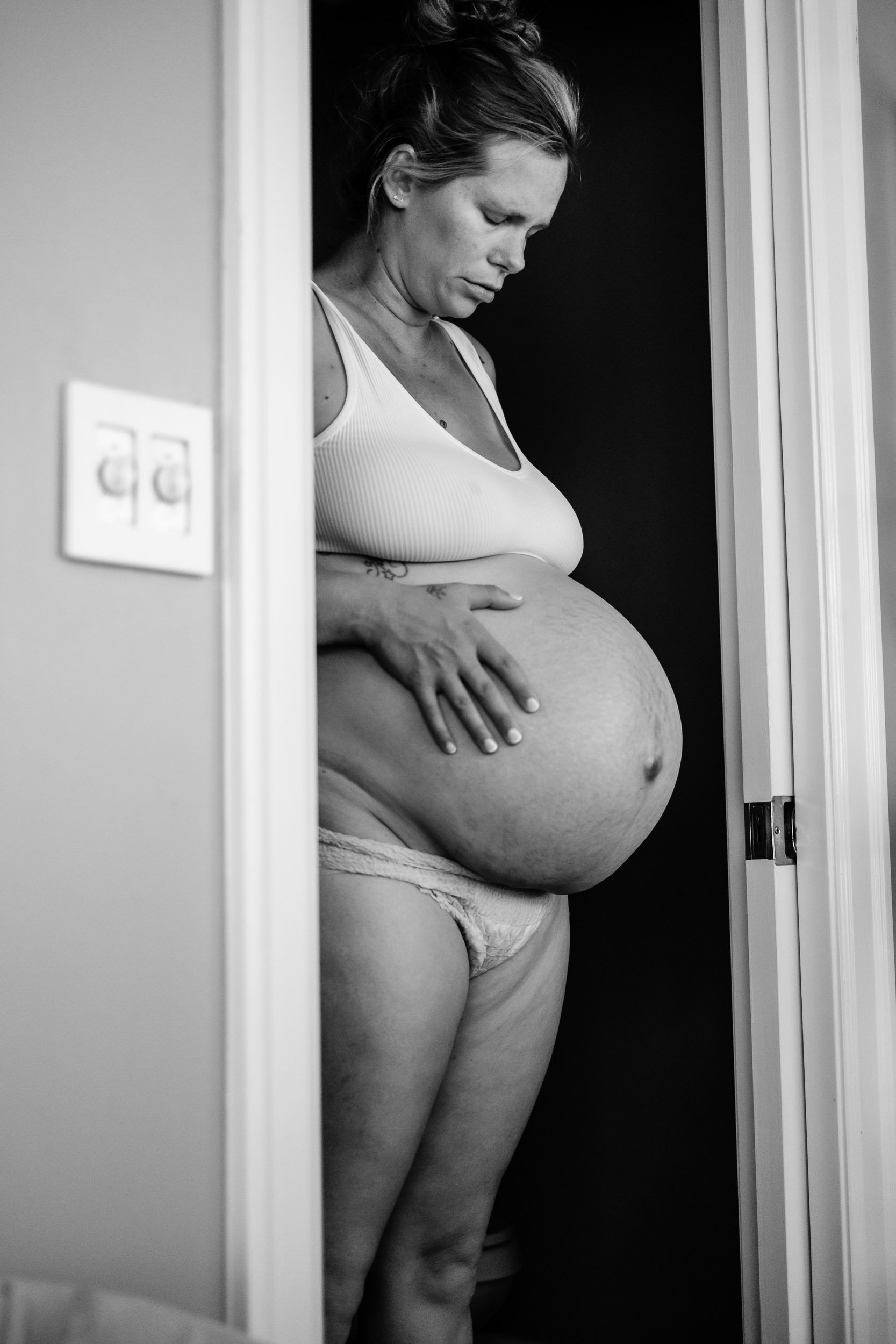 A pregnant mother is framed in a doorway during her labor at Puget Center Birth Center.