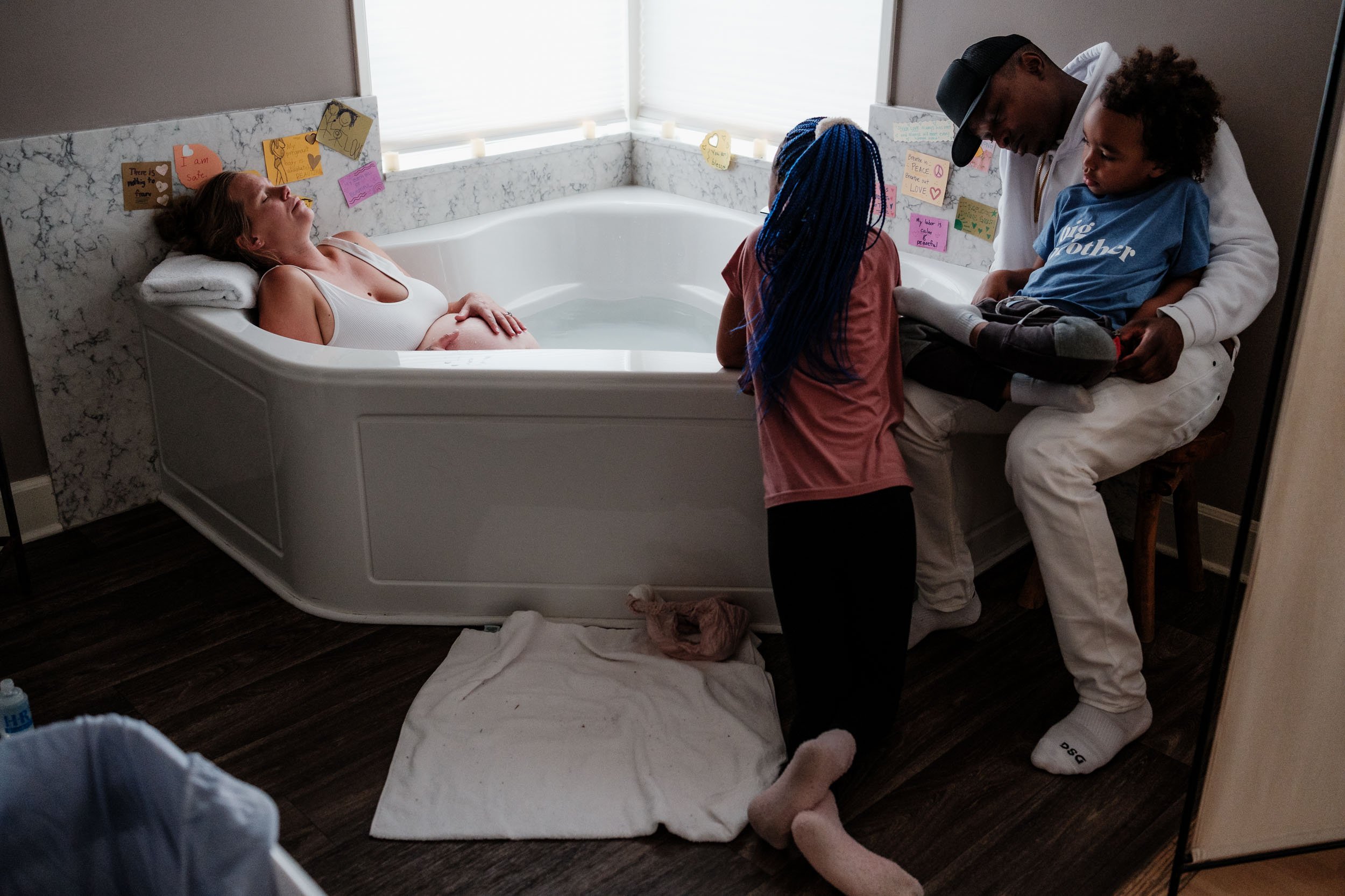 A family gathers round a birth tub as a mother labors.