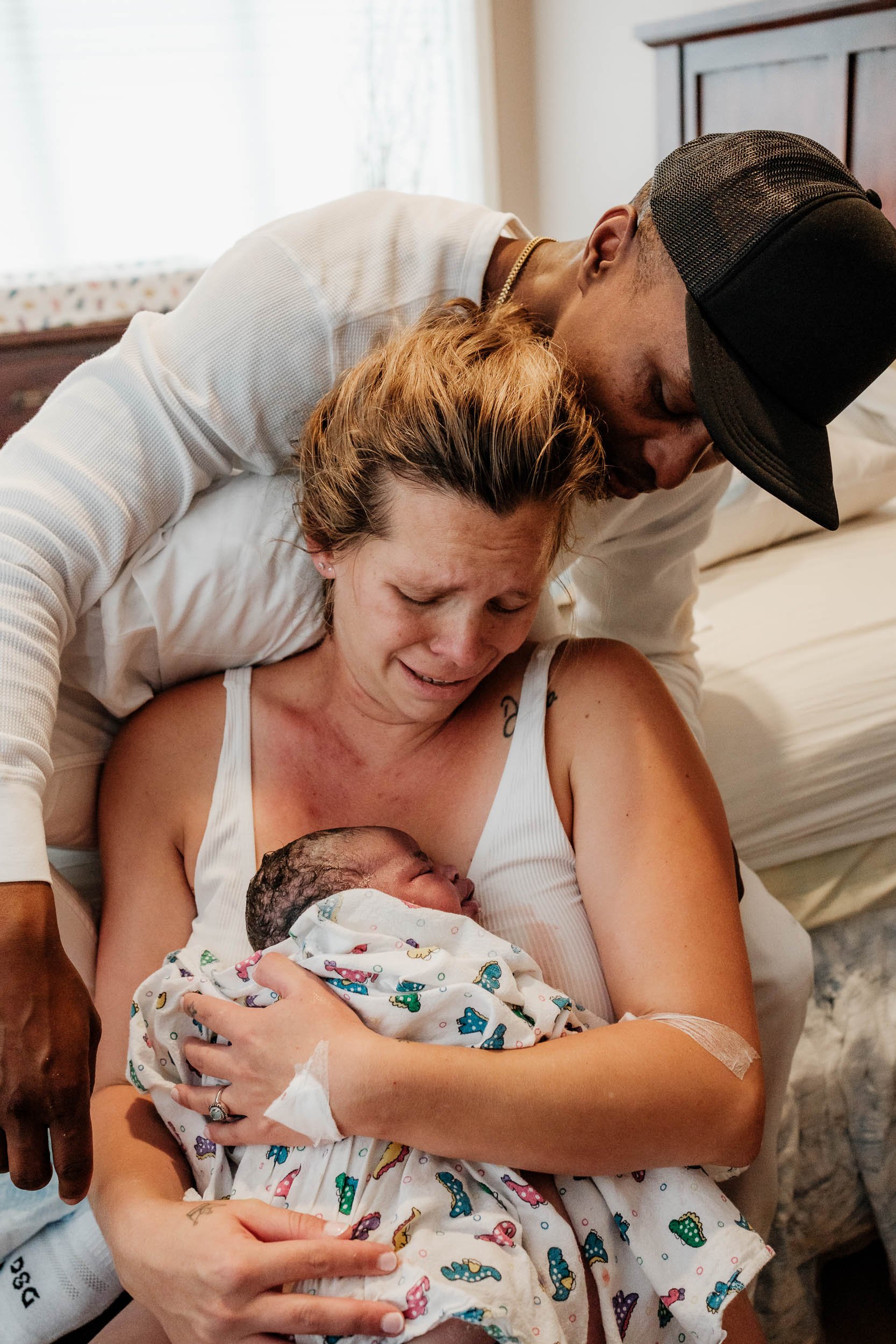 A mother and father look down lovingly at their newborn daughter immediately after birth at Puget Sound Birth Center.