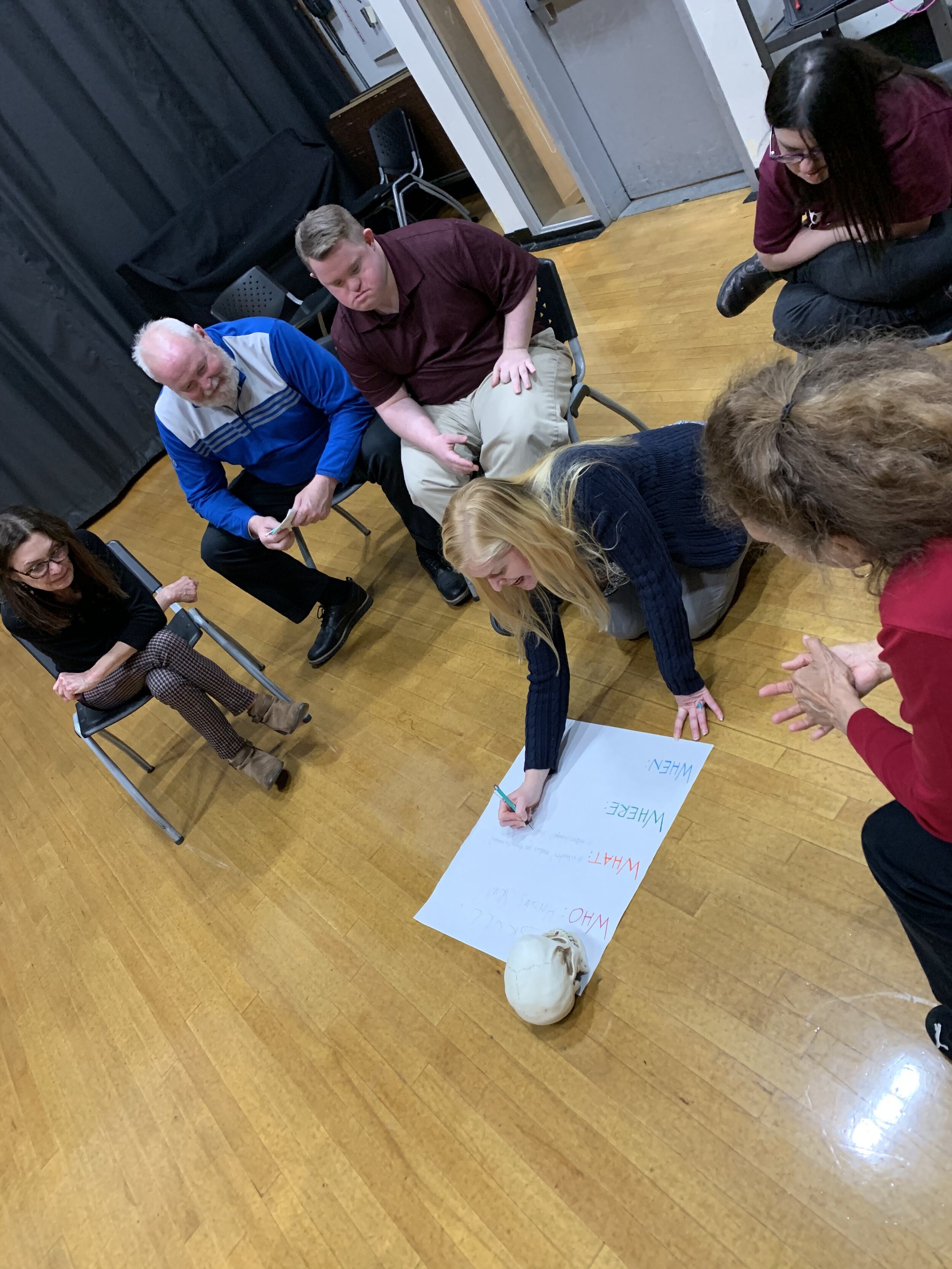 facilitator, Arin, leads a group in a devising exercise.