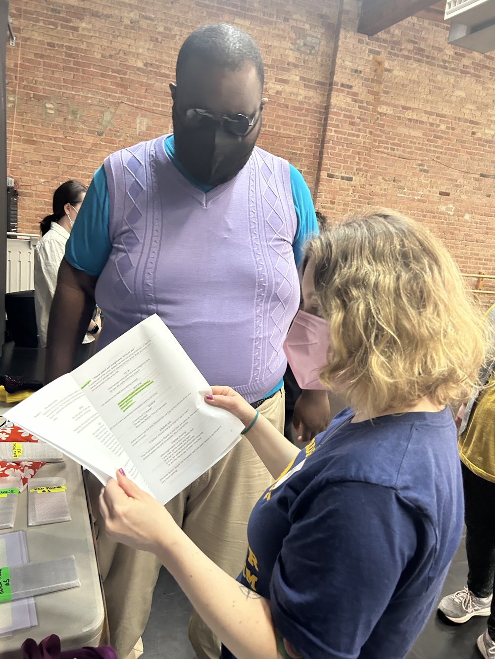  Actor Eric stands with facilitator Susan. Eric is in costume as Demetrius. Susan pages through a script talking Eric through key moments in Act 1 