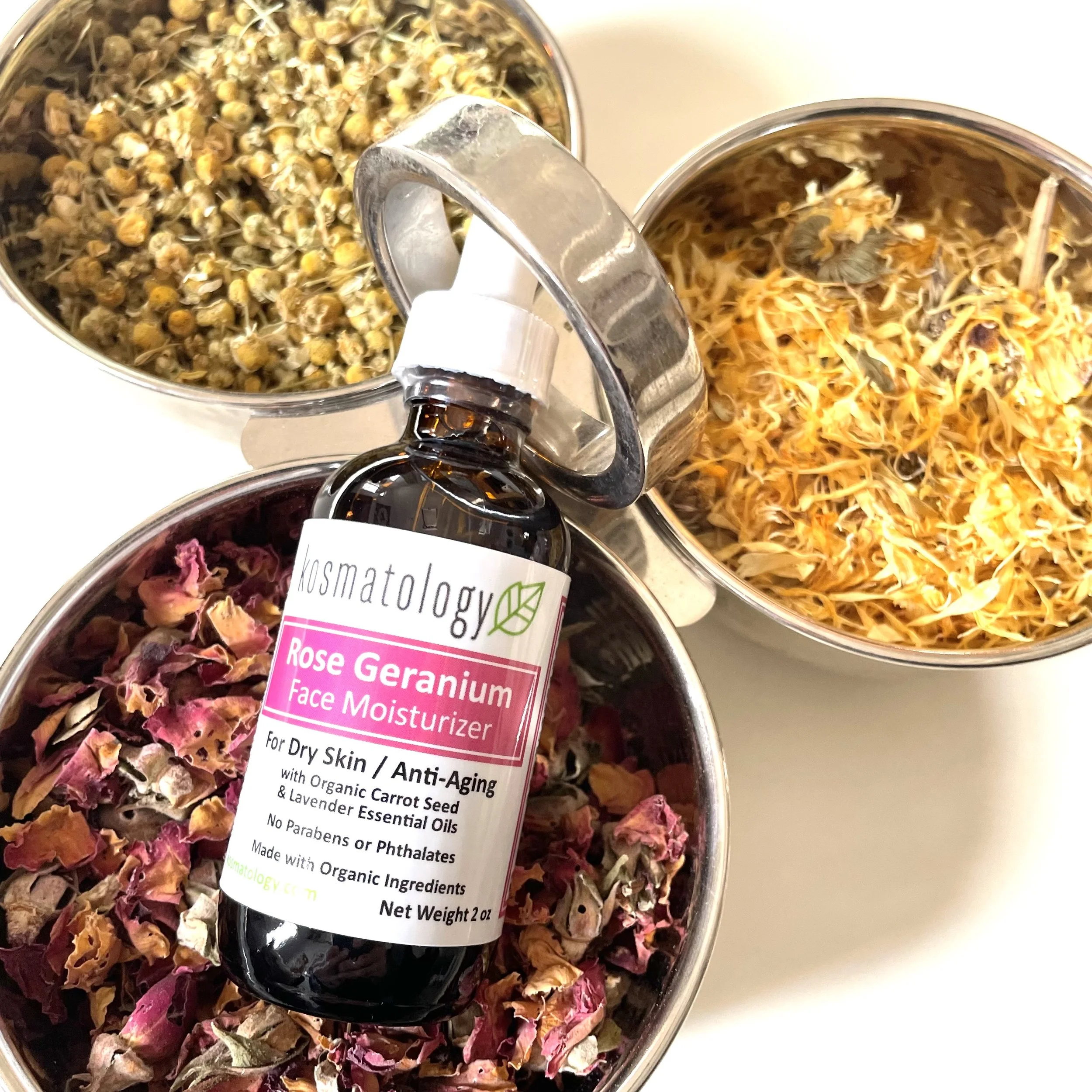 Rose Geranium face oil syurrounded by herbs usedin the oil, chamomile, calendula and rose geranium