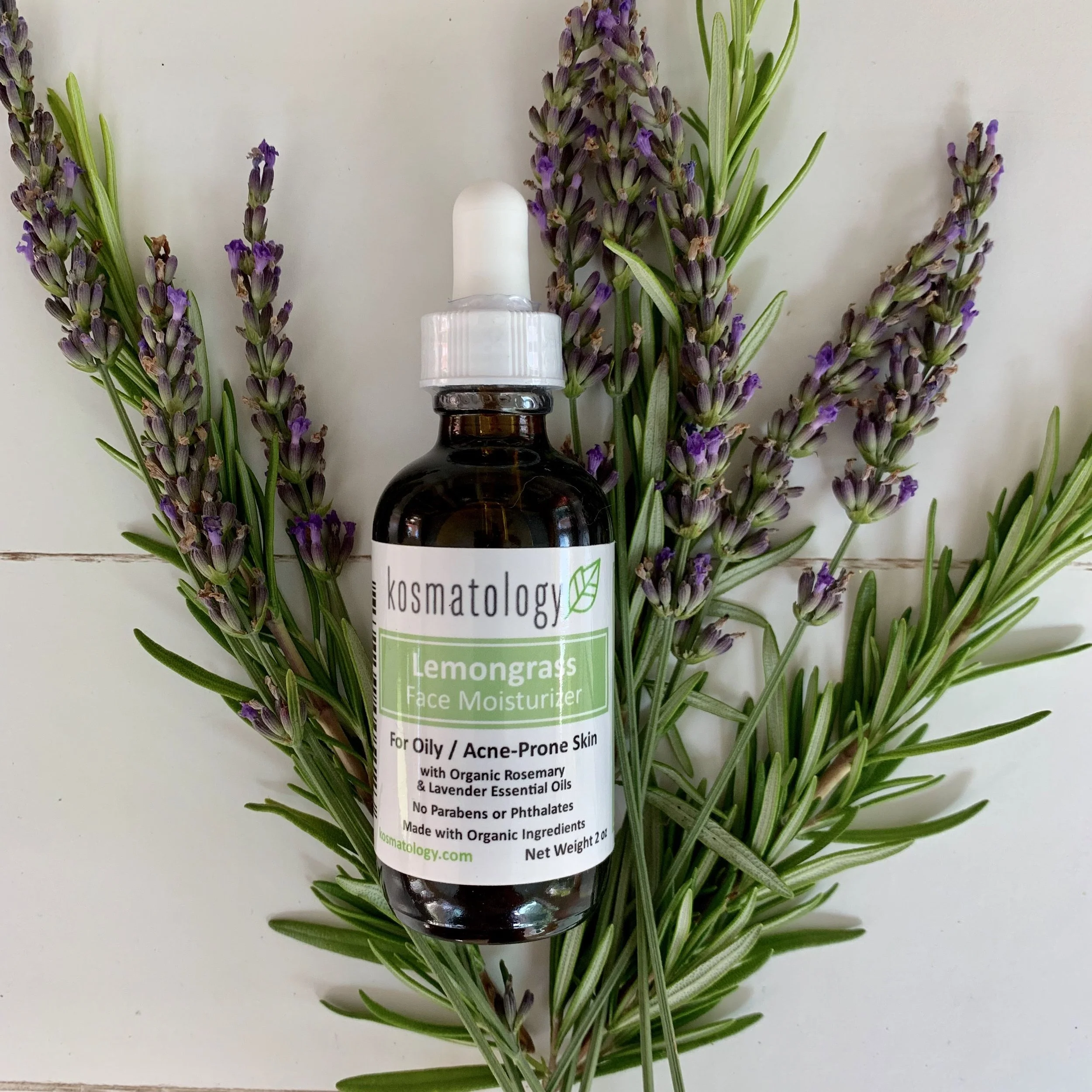 Kosmatology Lemongrass face oil pictured with fresh rosemary and lavender