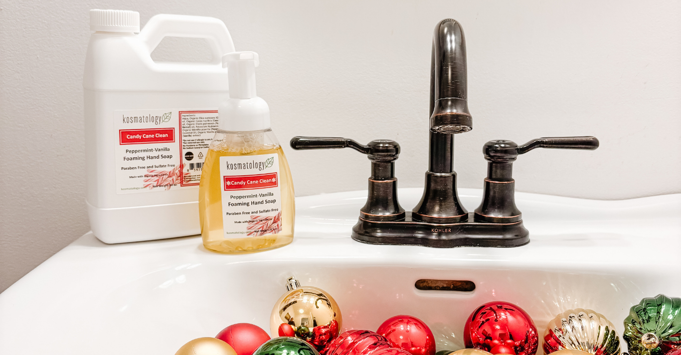 Candy Cane Clean hand soap refill and bottle sitting on a sink filled with brighly colored Christmas ornaments