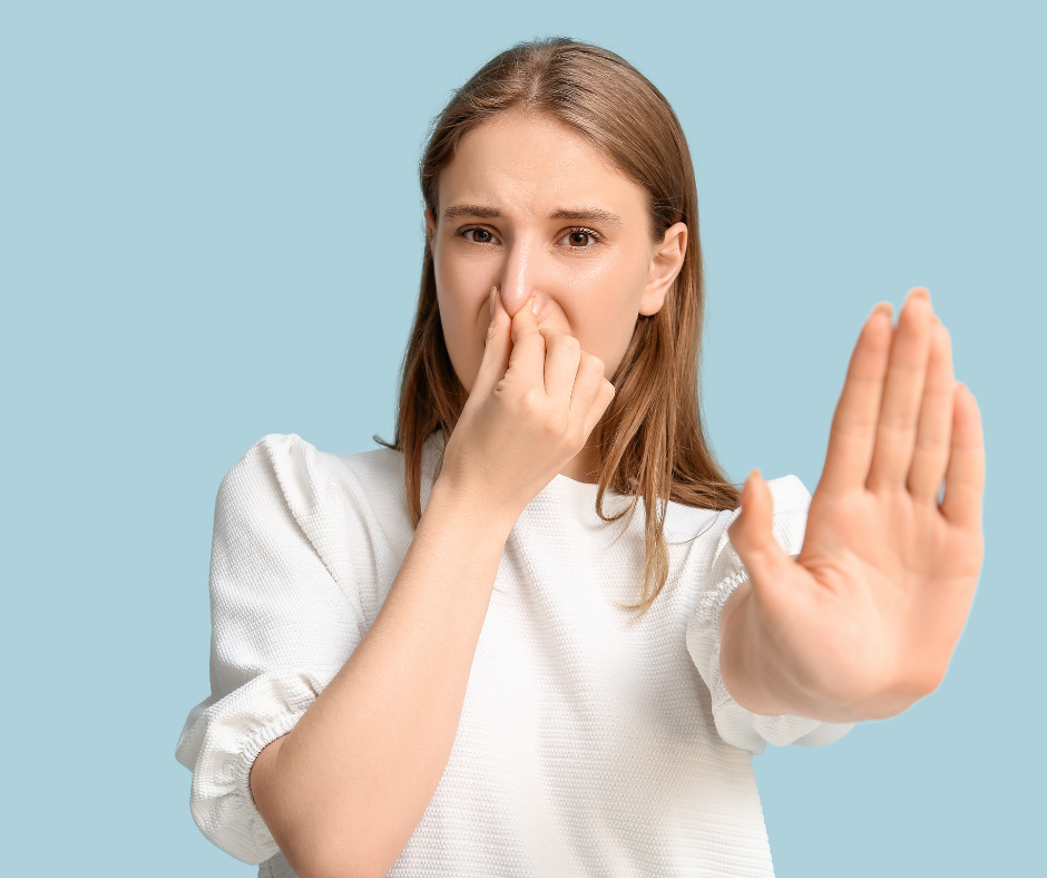 Woman holding her nose and pushing her hand out