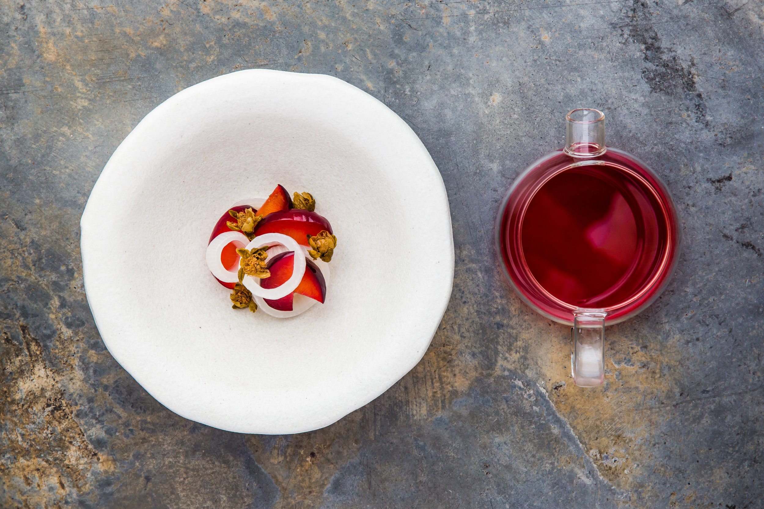 flat lay of fermented plums, onions and fried capers