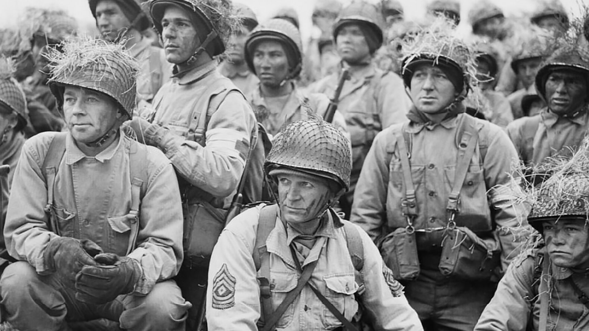 Imperial War Museum Photo: (EA 2304) (Part of the Foreign Office Political Intelligence Department (PID) Second World War Photograph Library: Classified Print Collection). First Sergeant Christopher McGuire (centre) and other men of the US 5th Infantry Division listen to an address by Lieutenant General George S Patton while on manoeuvres in Northern Ireland on 30th March 1944.