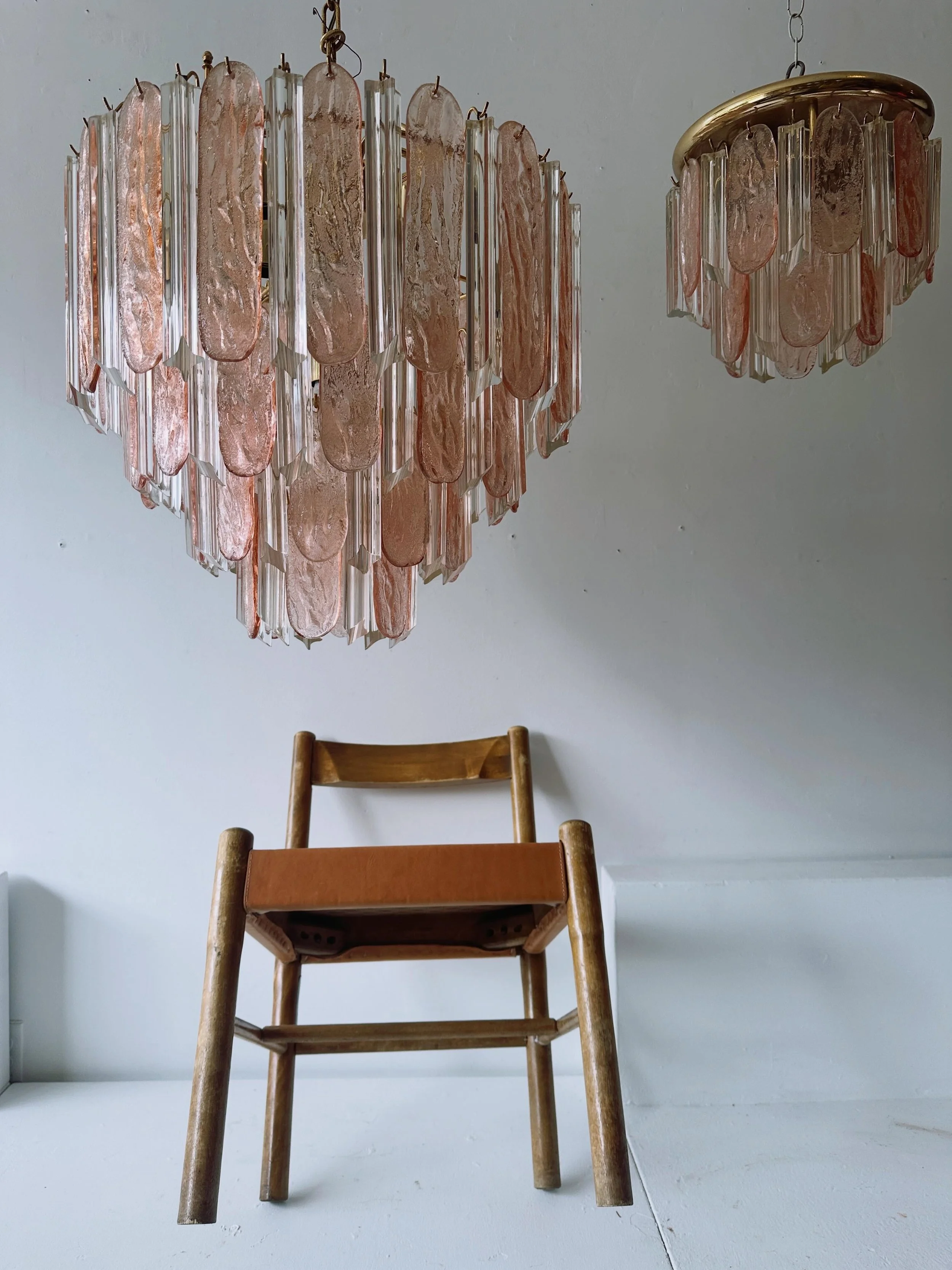 Two fantastic 1980s pink Murano glass fixtures.  A large tiered chandelier 24&rdquo; high, 22&rdquo; diameter, $975; and a smaller flush mounted fixture, 11 1/2&rdquo; high, 12 1/2&rdquo; diameter, $325 (one of the clear glass drops on the small fixt