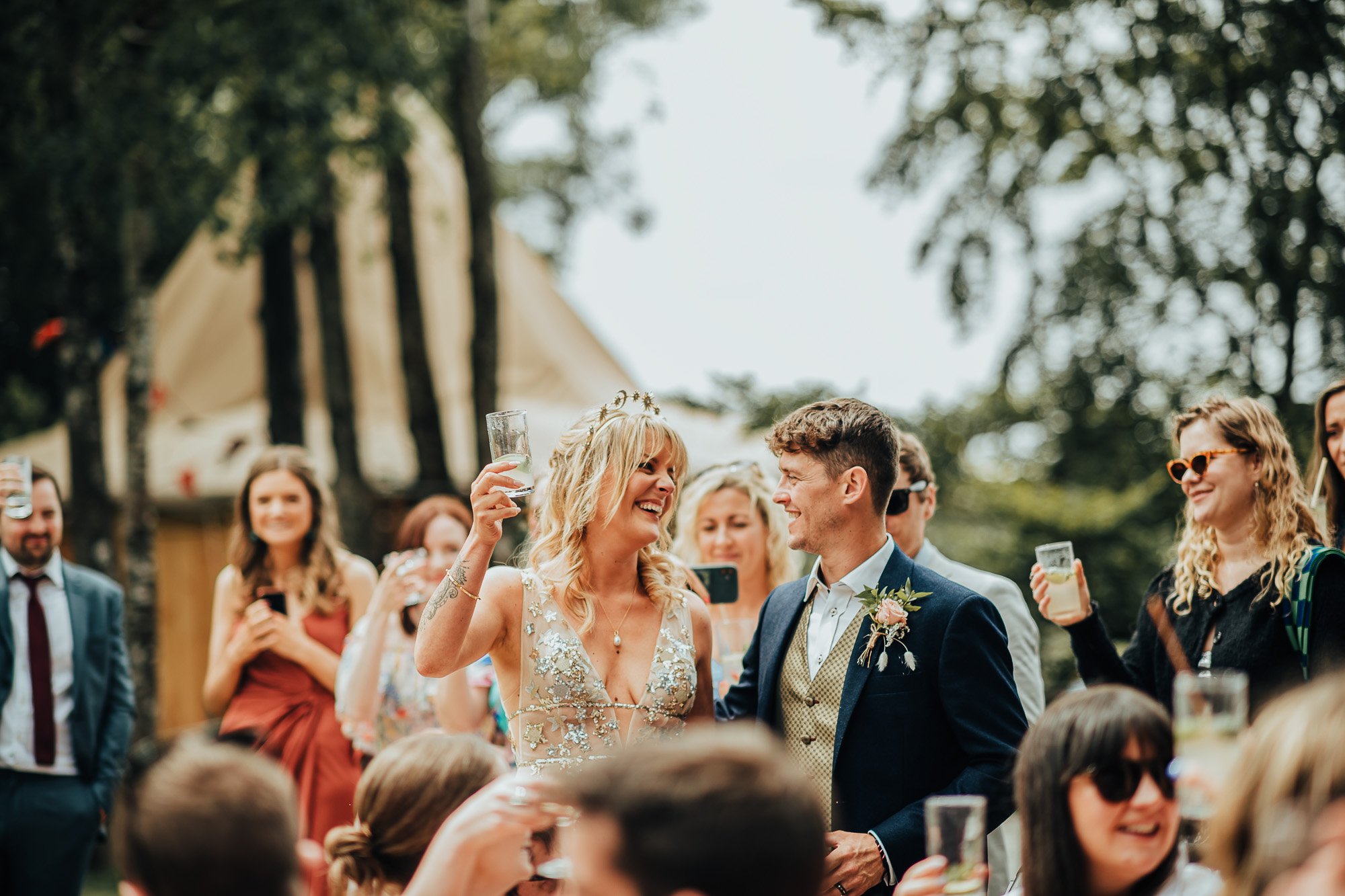 Bride and groom celebrating outdoors with guests