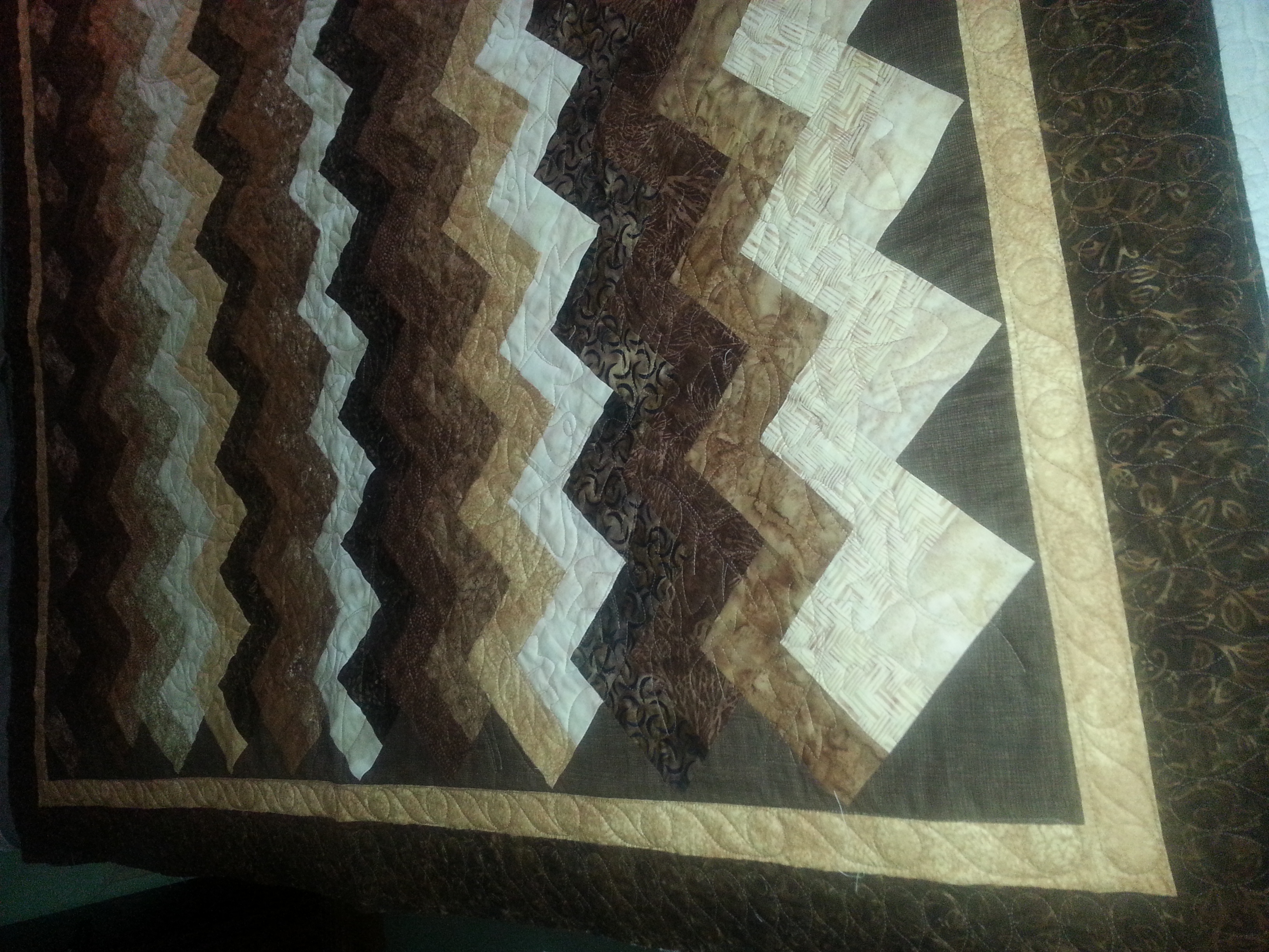 Custom quilting includes acorns and oak leaves in body, scroll in 1st border and ribbon candy in outer border.