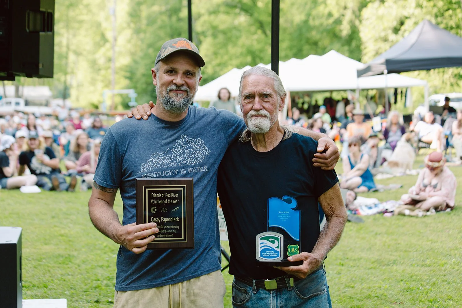 two men hold volunteer awards