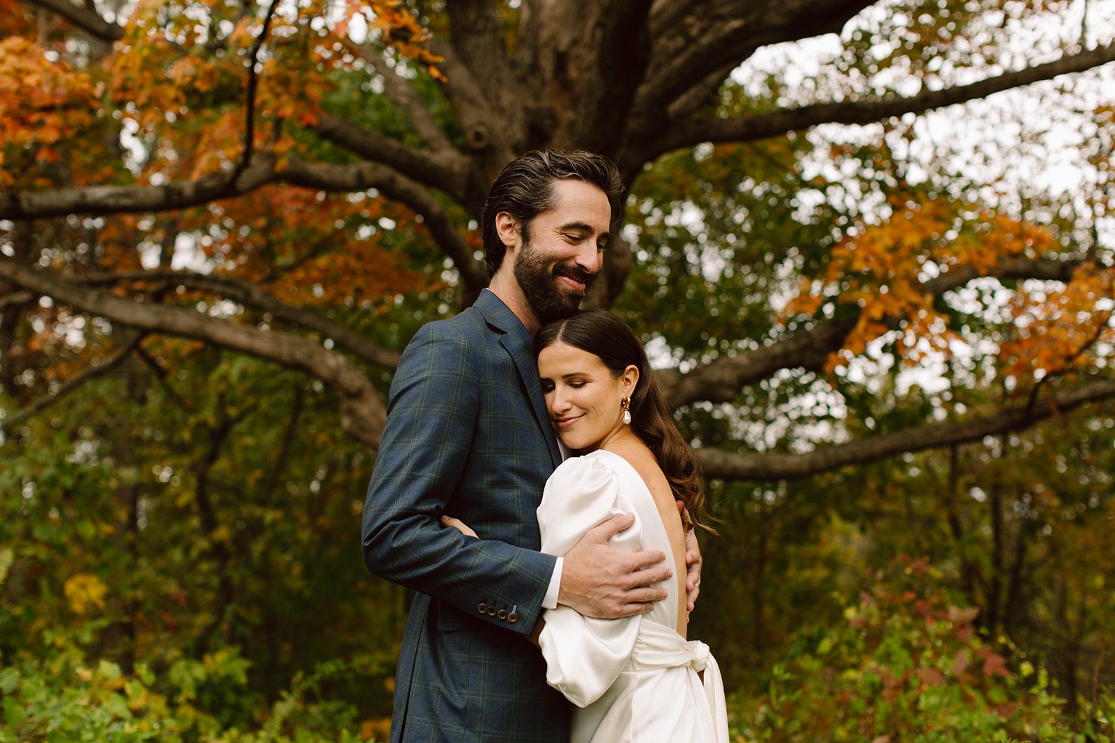 couple hugs under an autumn tree