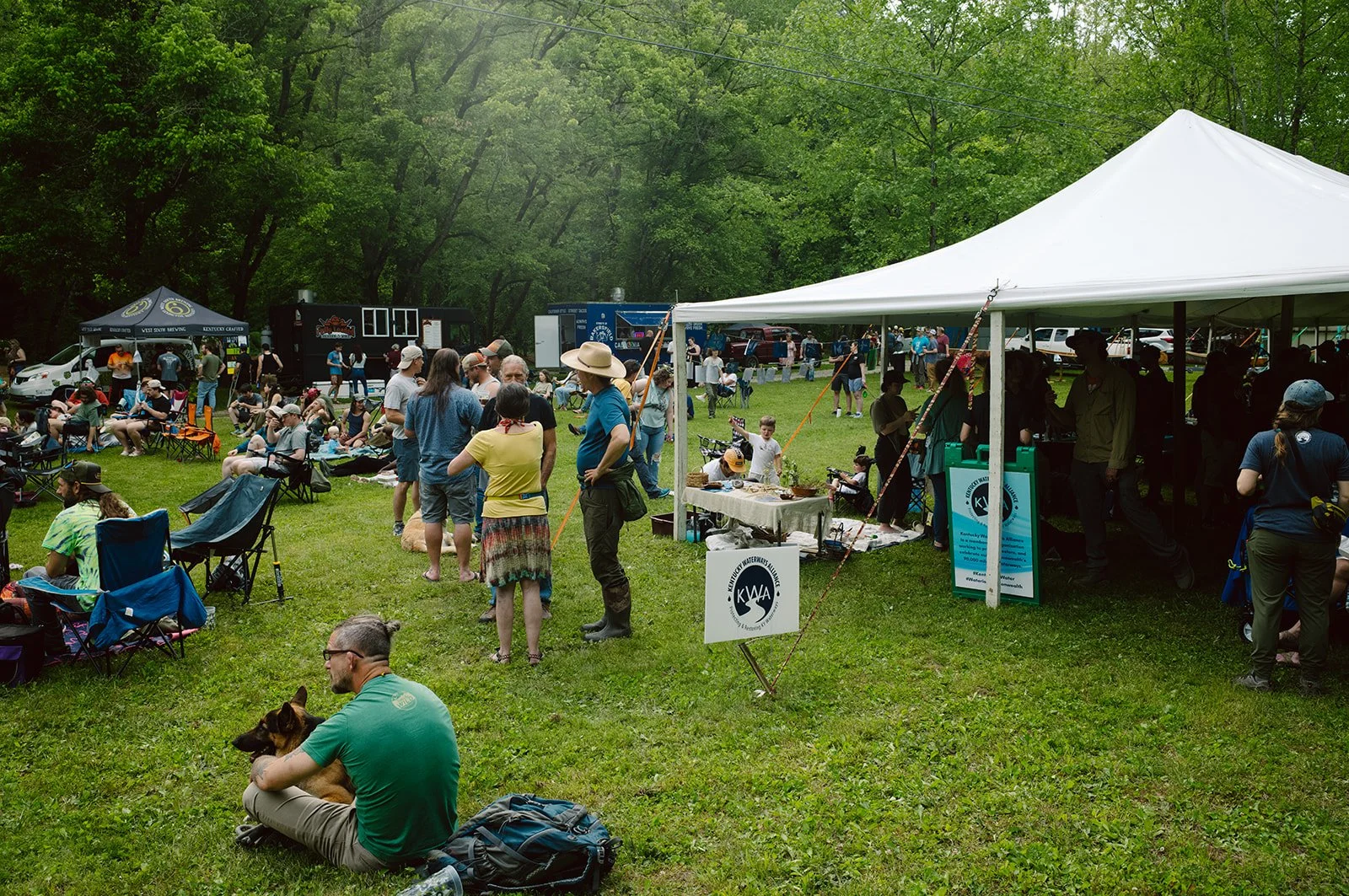 folks mingle outside of a white tent during an spring event