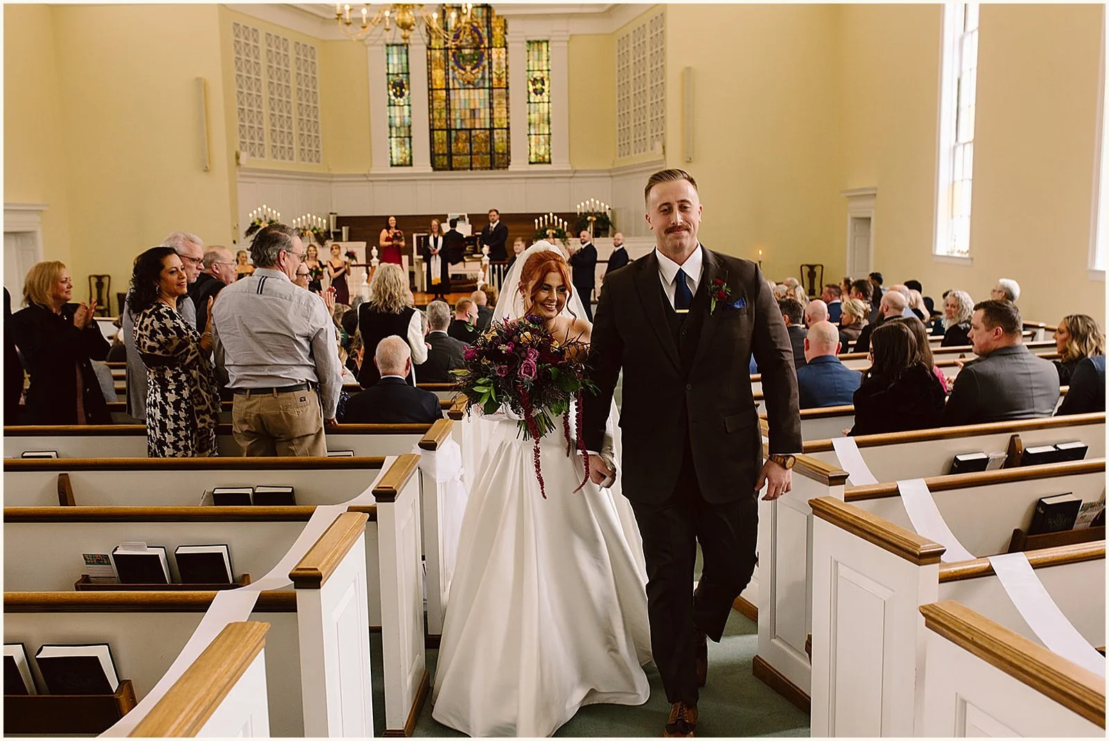 A bride and groom walk their recessional at a church wedding in Louisville.