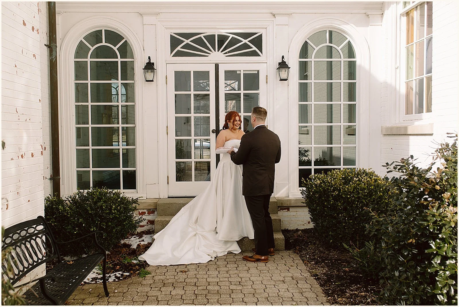 A bride and groom hold hands in a Louisville hotel courtyard.