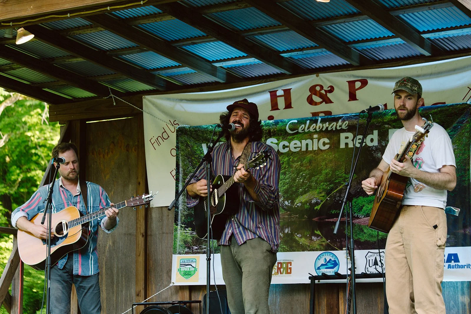 a band plays folk music and they all hold acoustic guitars