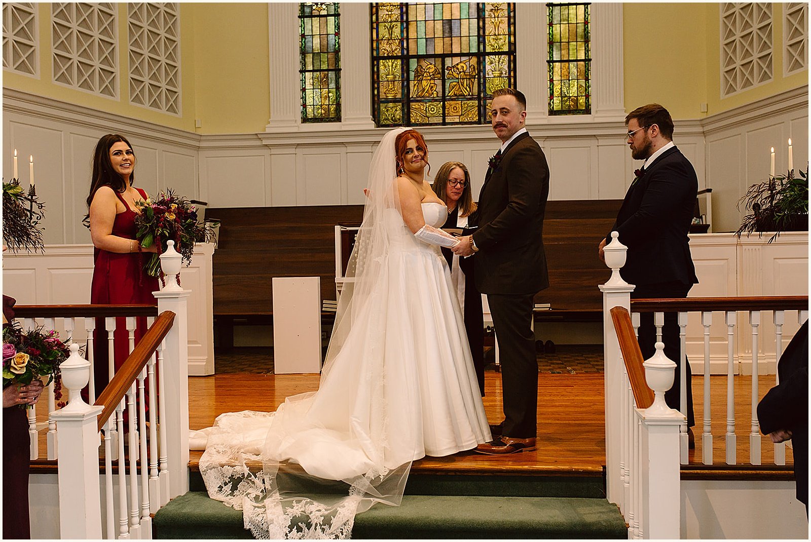 A bride and groom hold hands at the altar inside a Louisville church.