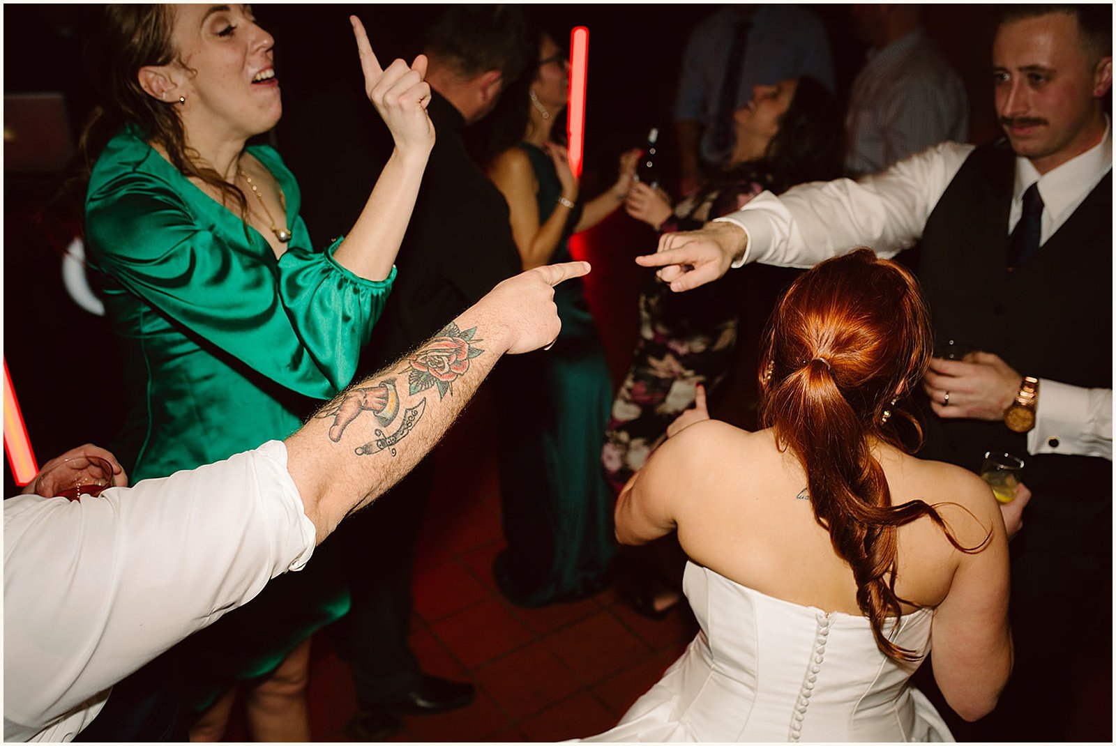 A groom points at a friend across the dance floor.