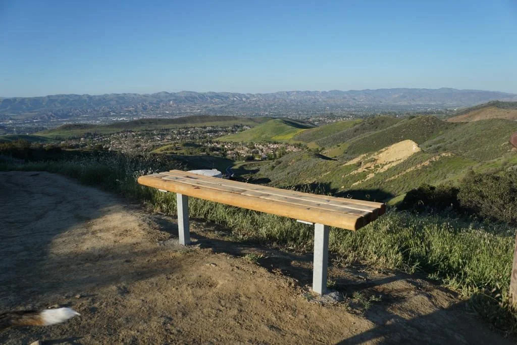 This bench is located at the juncture of the Sunrise and Meadow Vista Trails in the Lang Ranch Open Space and Long Canyon Trail , which is accessible via the Wood Ranch section of Simi Valley. Not a bad view, eh?