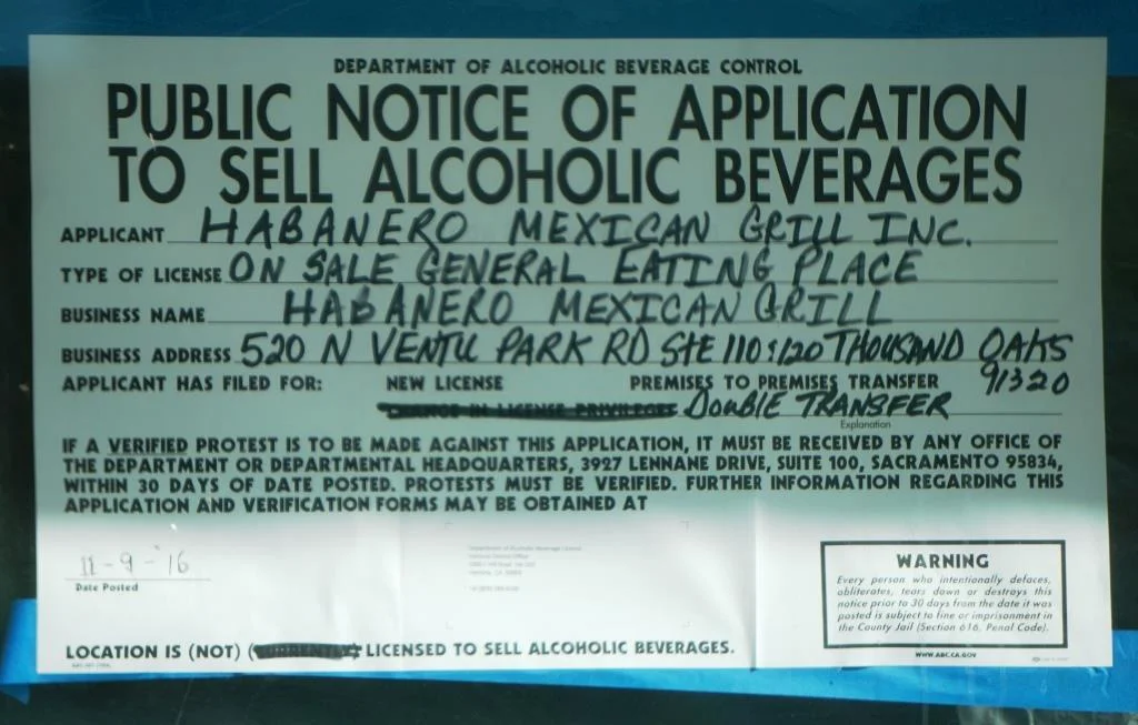 Sign indicating a transfer of a alcoholic beverage serving license has been applied for. It is definitely a must to have a cold beer or margarita with your fajitas.
