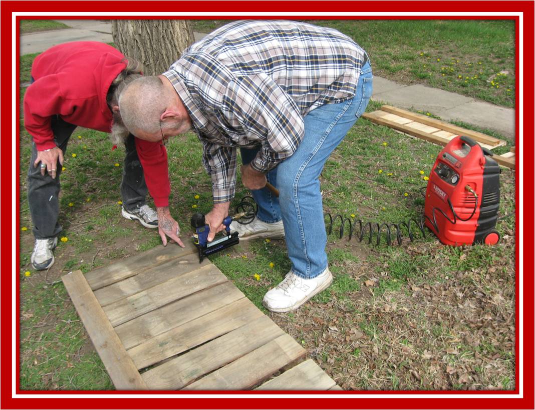Larry instructing Mark on the use of his nail gun
