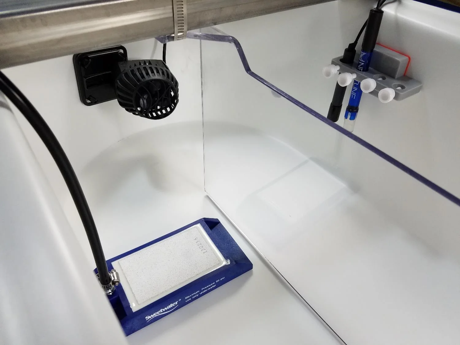 The blue and white block is a ceramic gas diffuser used to sparge a fine mist of CO2 into pond water. The blue sensor probe is a Neptune pH probe (but any pH probe with a BNC connector works). Also pictured is a temperature sensor (black) and the impeller mixer used in the RW0.5i system.