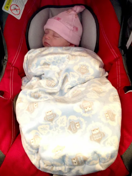Puffy swaddle applied on top of the straps and tucked around body. Carseat shown is Chicco Keyfit 30 with infant insert.