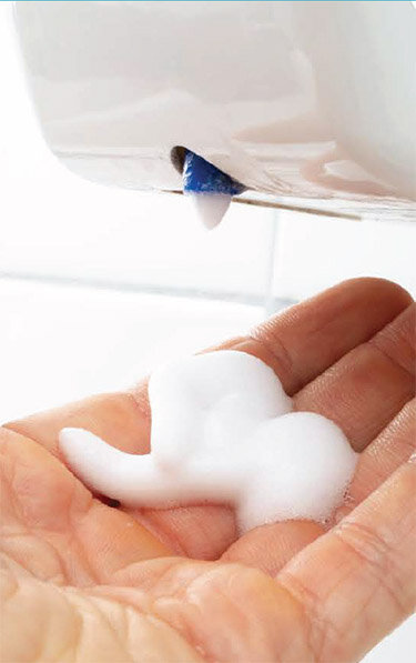  . . . and dispenses a white foam sanitizer. 