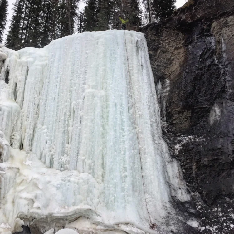 Ryan celebrates on top of Salt Falls. He rigged a rappel from an anchor to the left and redirected the ropes over an ice hump on top, so they would run down the ascent line. During the rappel, the ropes popped over the ice hump and he took a violent swinging fall.